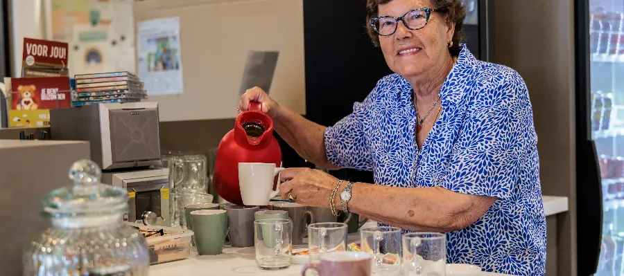 Vrijwilliger schenkt koffie in